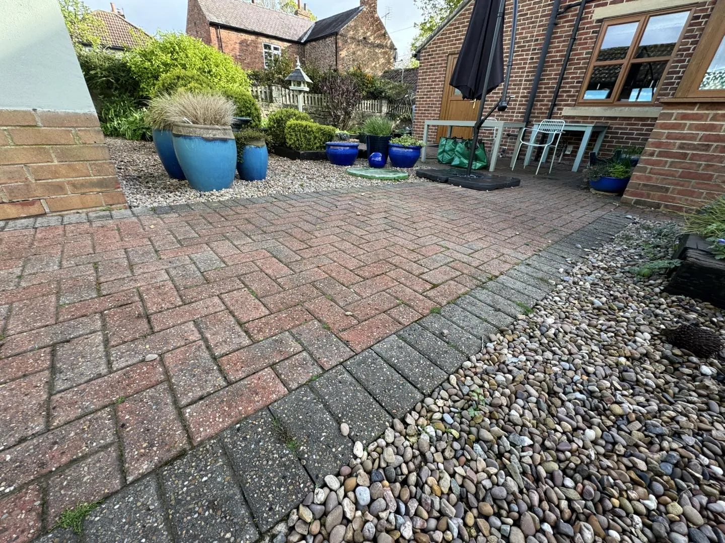 A block-paved Thirsk driveway before cleaning, darkened with grime, algae and moss